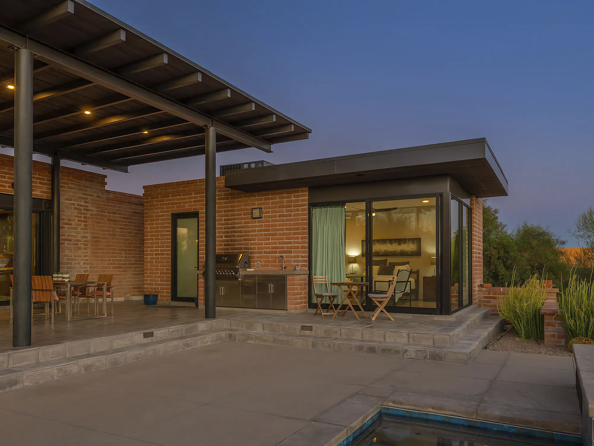 Covered patio with steel posts and a timber ceiling at Camino Antonio, looking out to the desert