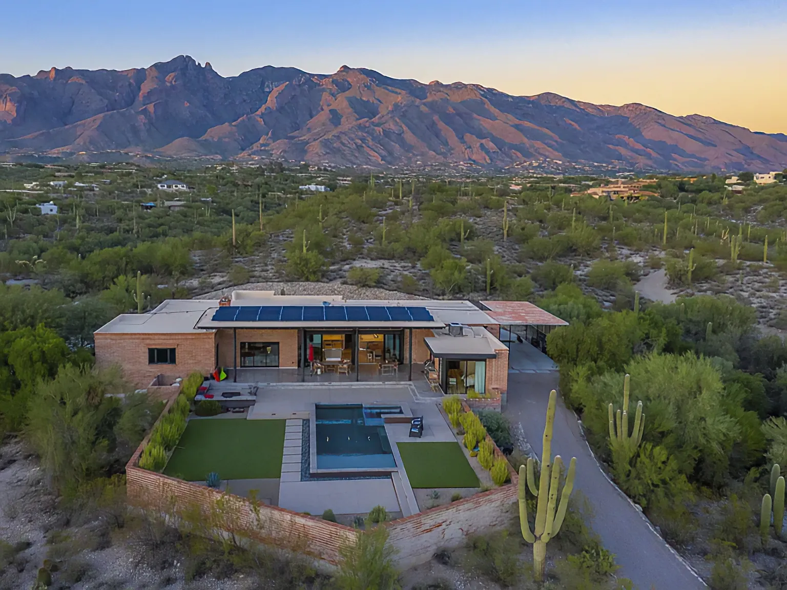 Aerial view of the Camino Antonio home at dusk, pool and desert with the Catalinas behind
