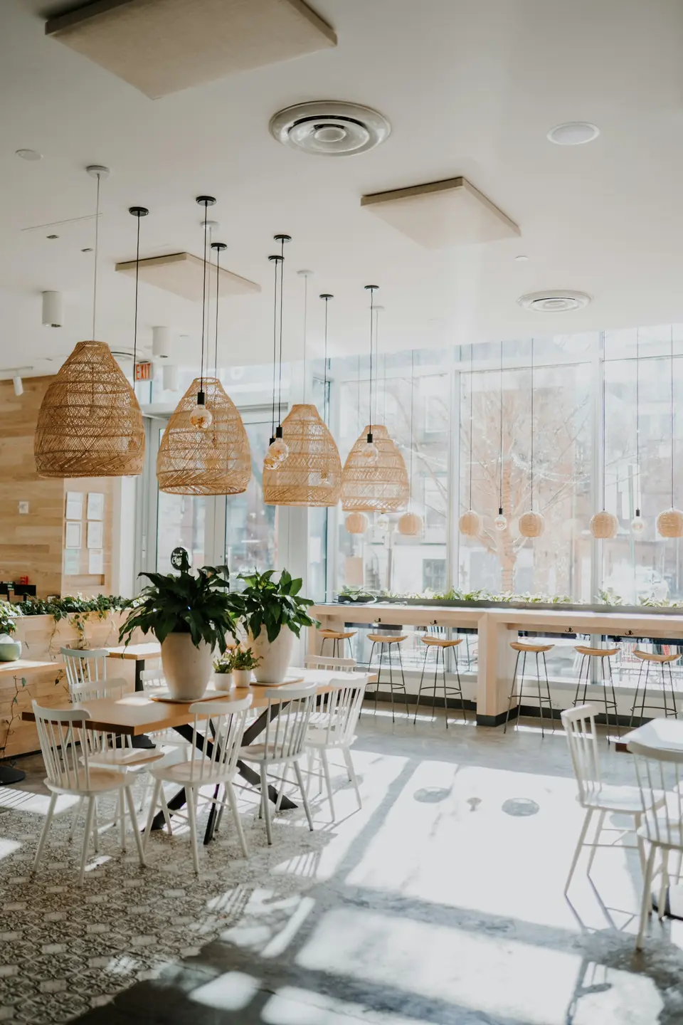 Bright modern cafe interior with woven pendant lighting and communal seating