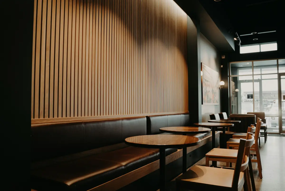 Upscale restaurant lounge seating with a wood-slat feature wall and warm lighting